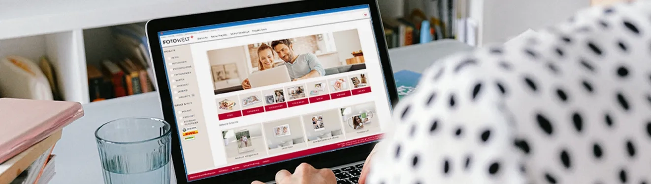 Fotosoftware für kreative Online-Projekte Eine Person nutzt die ROSSMANN Fotobuch Software auf einem Laptop, um Fotoprodukte wie Bücher und Kalender zu gestalten.