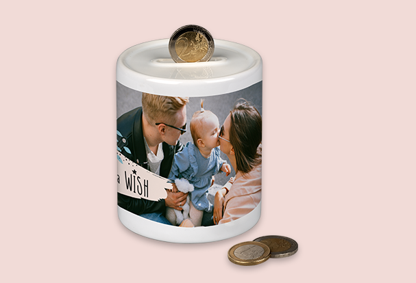 Weiße Spardose aus Keramik mit Foto und Münzschlitz Eine weiße Spardose mit persönlichem Familienfoto und einem Münzschlitz auf dem Deckel, dekoriert mit Münzen.