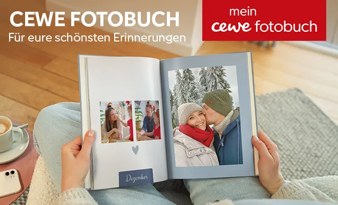 Person betrachtet ein Fotobuch mit Winterfotos, darunter ein Paar in einer Schneelandschaft.