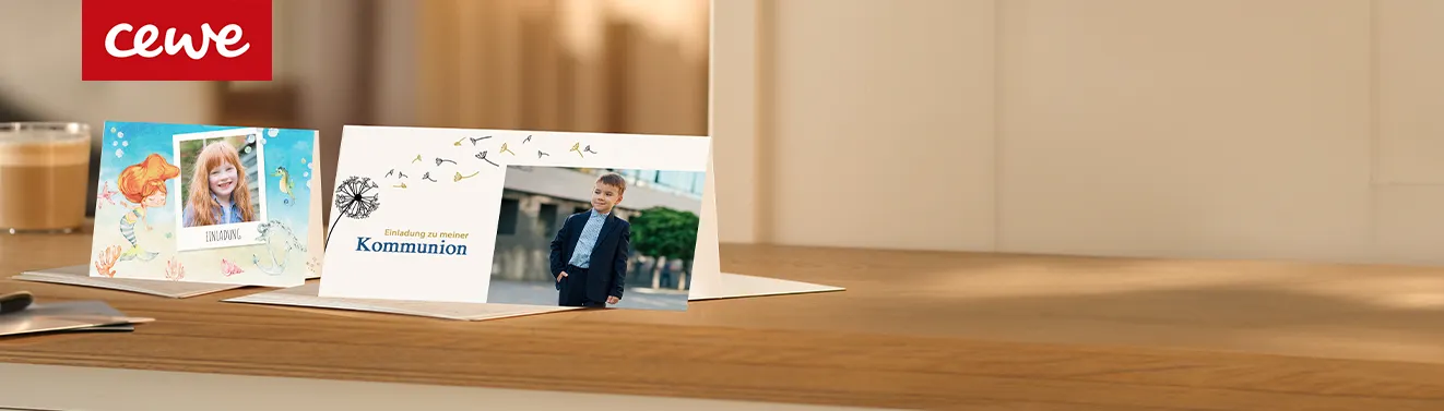 Grußkarten von Cewe Personalisierte Grußkarten, Thema Kommunion und Einladung Kindergeburtstag, stehen aufgeklappt auf einem Holztisch