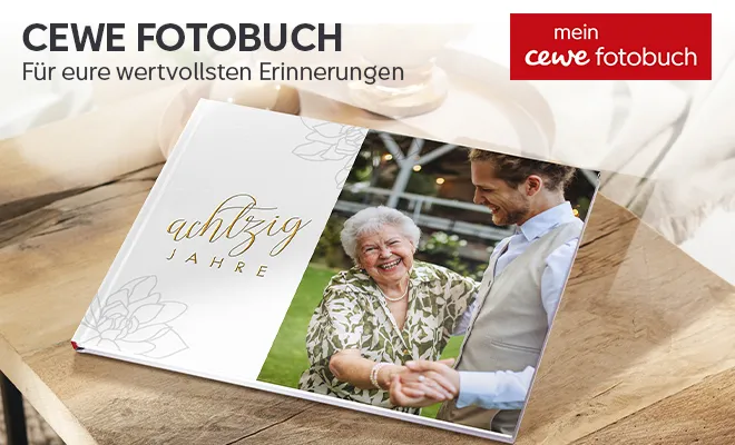 Fotobuch von CEWE Personalisiertes geschnlossendes Fotobuch liegt auf einem Holztisch