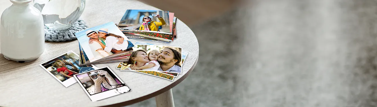 Fotos entwickeln und als Fotoabzüge bestellen Fotos als hochwertige Fotoabzüge in verschiedenen Formaten auf einem Tisch